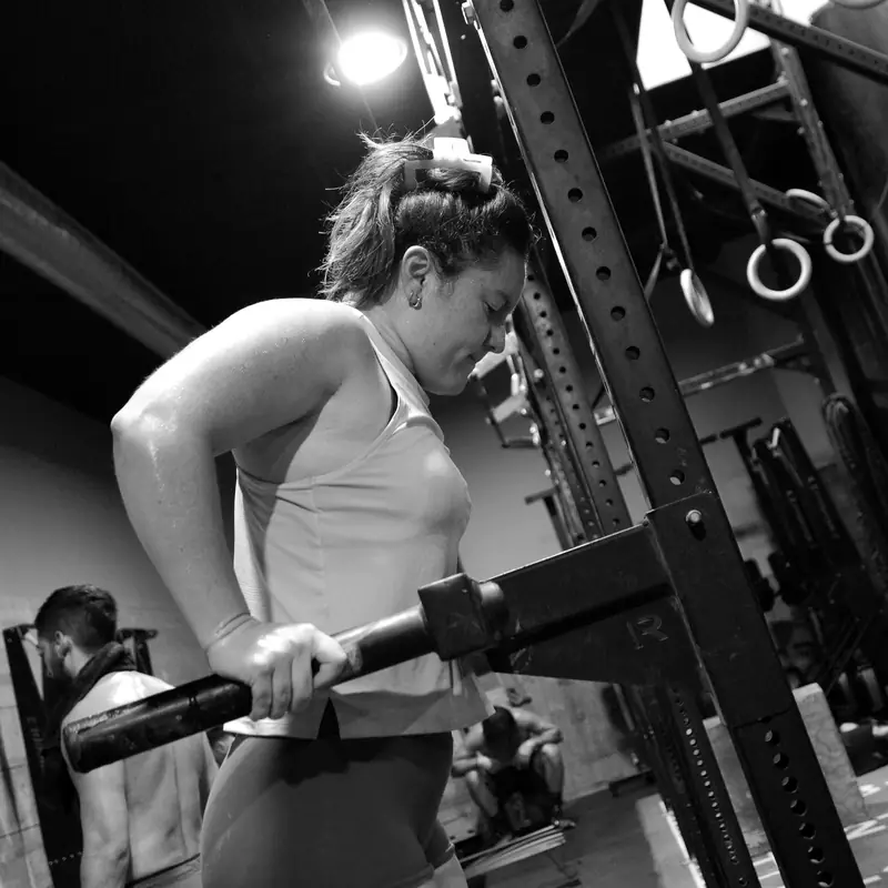 Atleta agarrando la barra en el rack de sentadilla